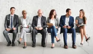 3 men and 3 women sitting in chairs next to each other