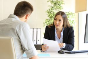 woman holding a piece of paper talk to a man