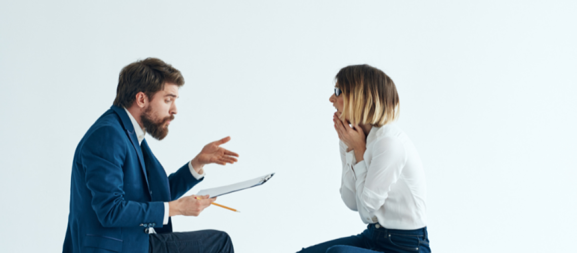 Man and woman sitting across from teach other talking with emotion