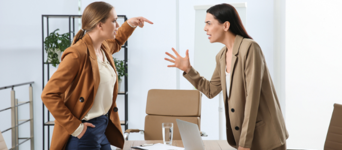 Two women expressing emotion, one is pointing at the other