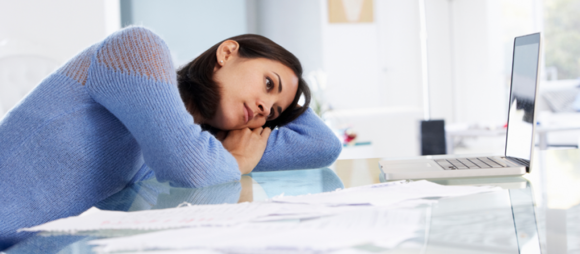 woman leaning on a desk, laying head on her arm