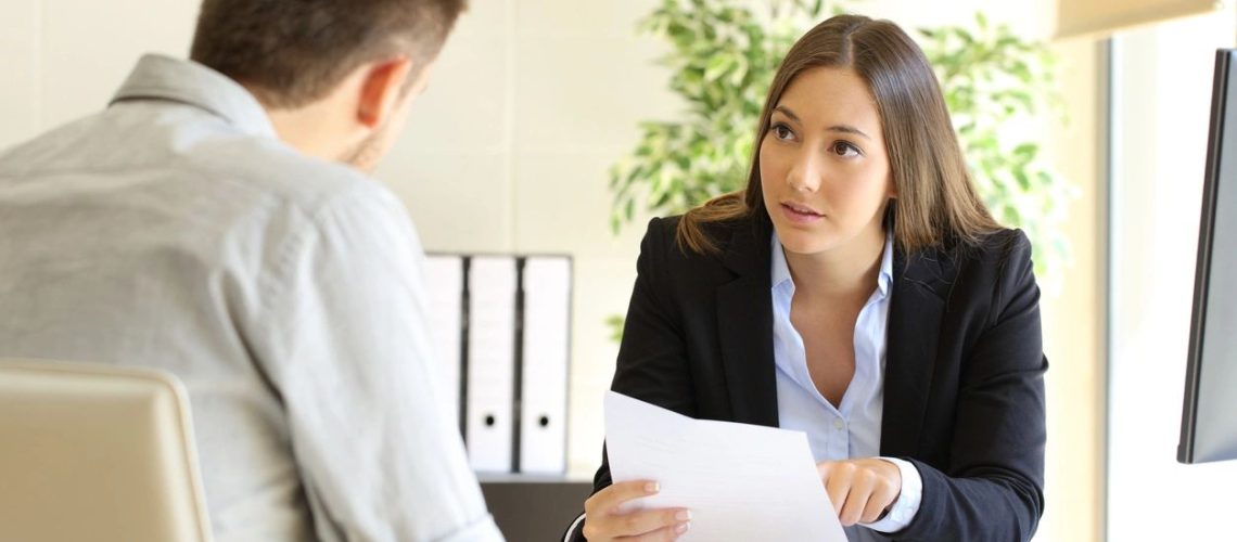 woman holding a piece of paper talk to a man