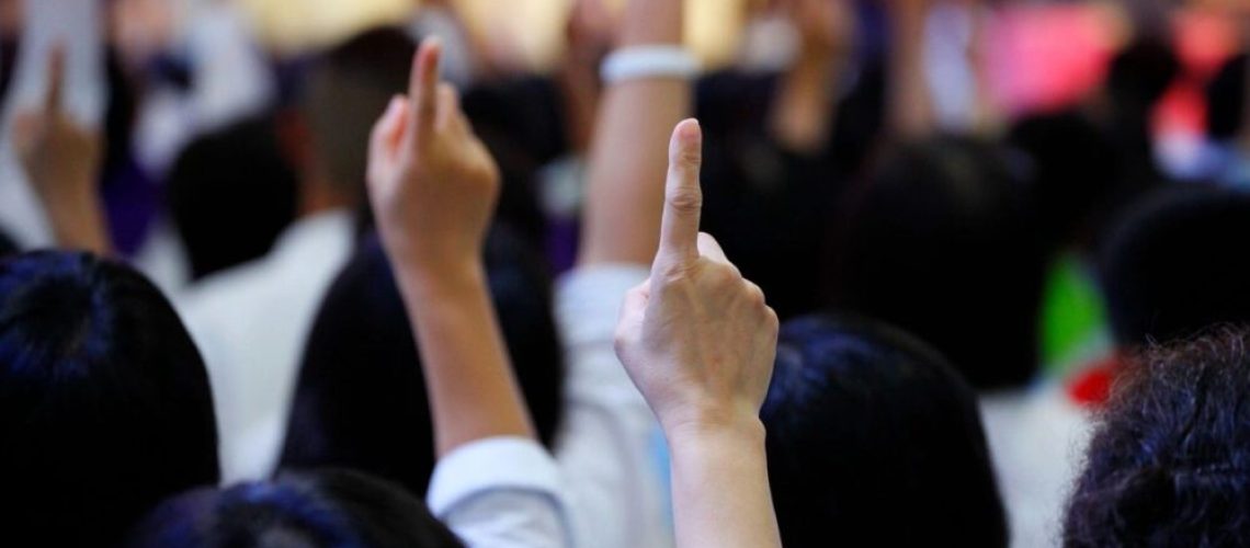 People raising their hand pointing a finger up